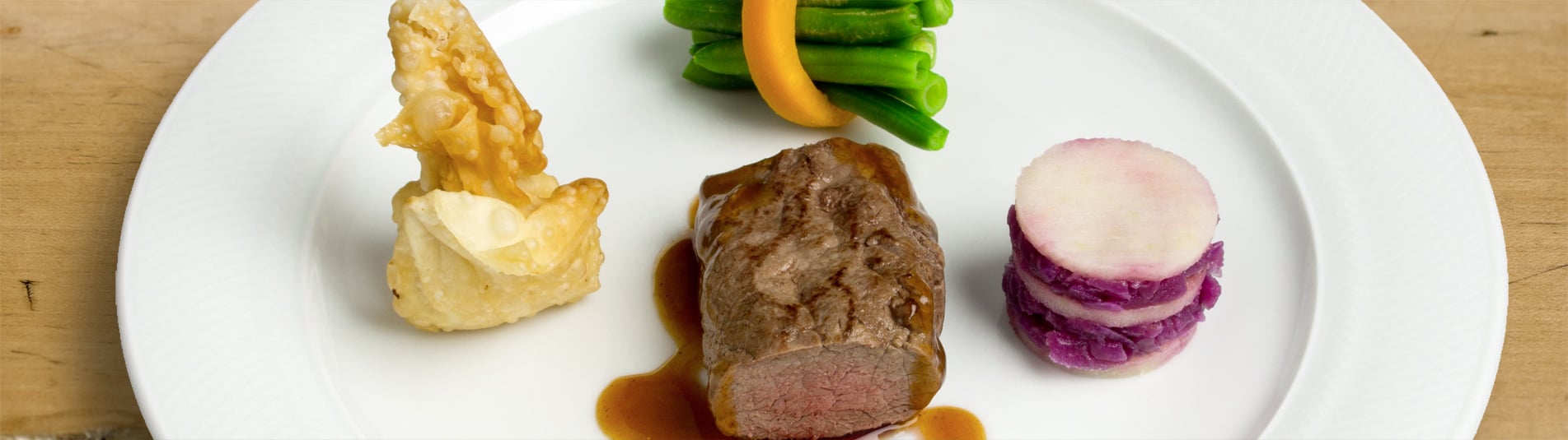 Rosa gebratener Hirschrücken mit Erdäpfelstrudelsäckchen und Rotkraut Millefeuille